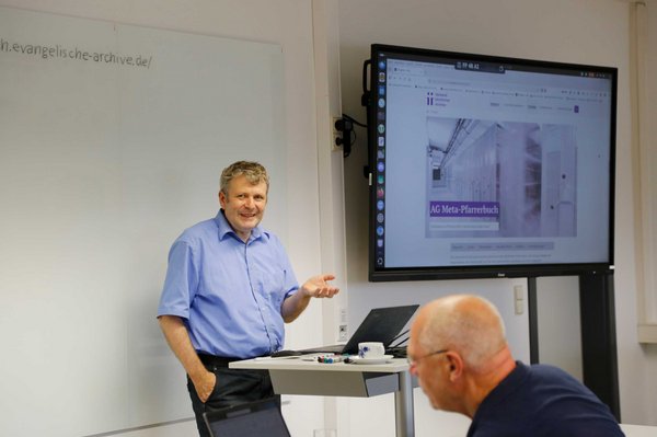 Prof. Thomas Riechert ein Mann spricht am Pult neben einem großen Bildschirm