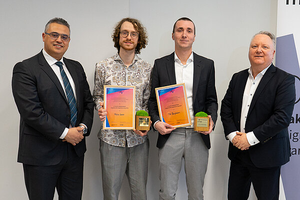 Gruppenfoto mit den beiden Preisträgern in der Mitte sowie Prorektor Forschung (links) und Stifter von Actemium (rechts)