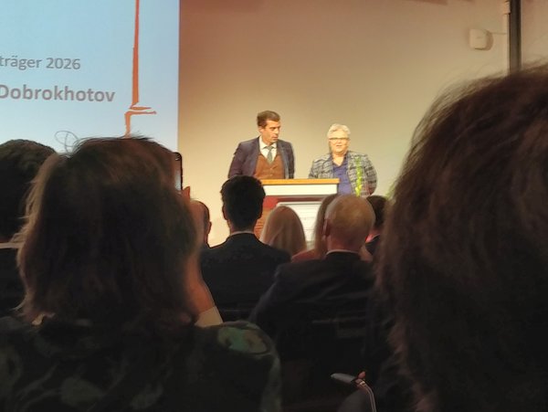 Roman Dobrokhotov erhält den Preis der Medienstiftung. (Foto: Gabriele Hooffacker) zwei Personen auf Bühne bei Preisverleihung