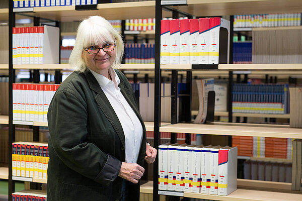 Gabriele Hooffacker Eine Frau steht vor einem Bücherregal