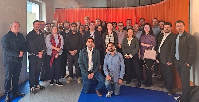 viele Menschen stehen für ein Gruppenbild in einem Raum